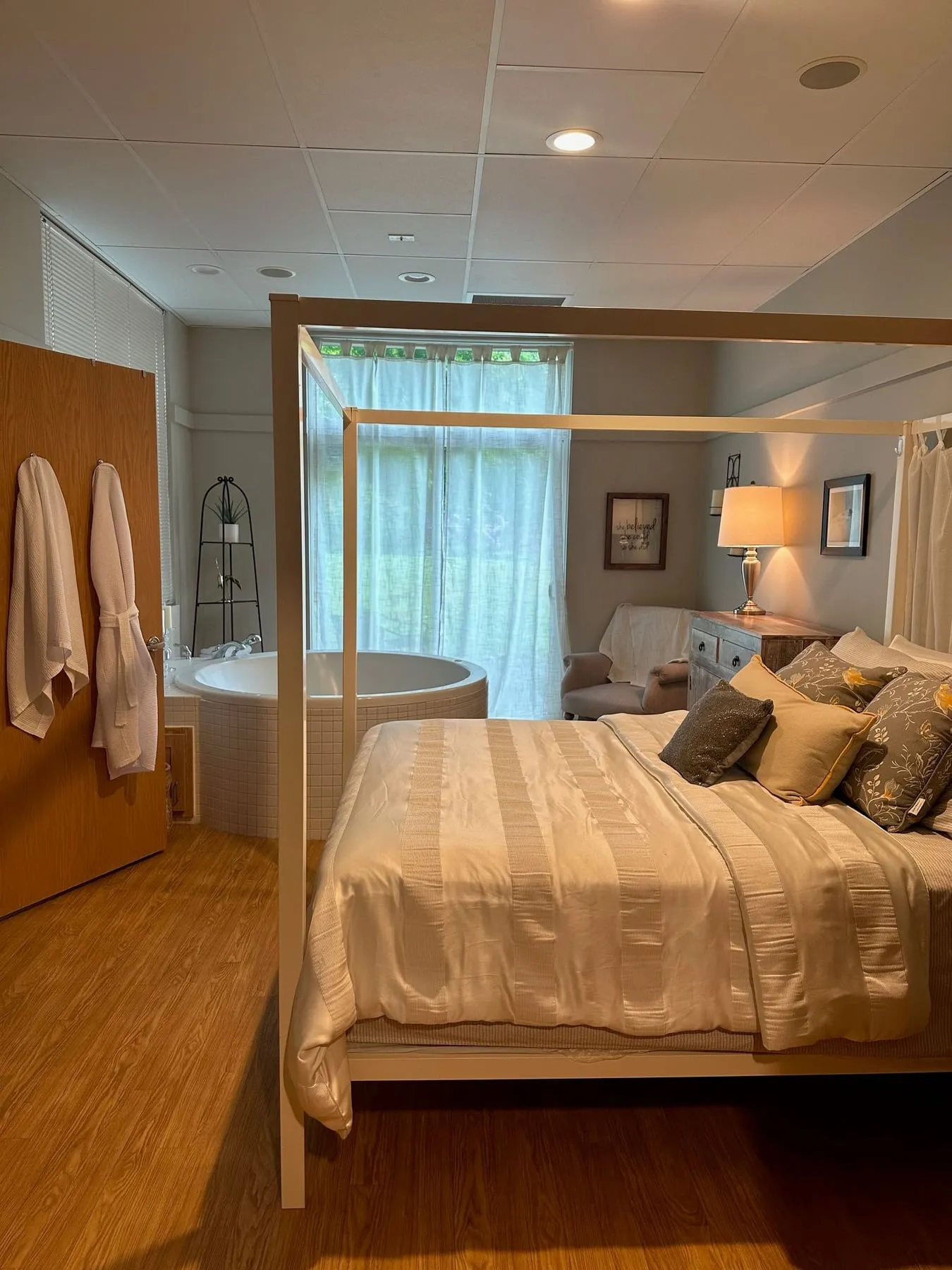 A birth suite with a canopy bed and a corner birth tub